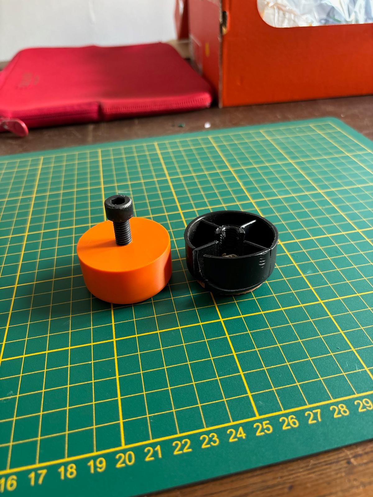 Pied réglable noir et sa copie orange imprimée en 3D